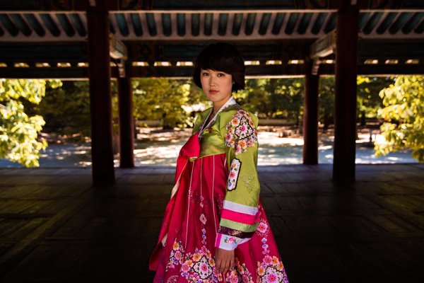 Cô gái tóc ngắn trong trang phục truyền thống màu sắc rực rỡ tại bảo tàng Koryo ở Kaesong