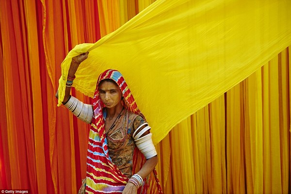 Người phụ nữ nhuộm vải, phơi khô ở một cơ sở sản xuất phục trang truyền thống sari.