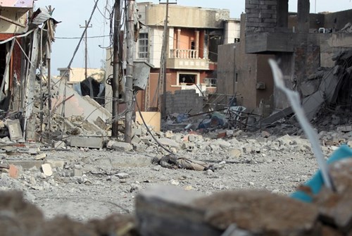 Xác của một phiến quân IS nằm giữa đống đổ nát