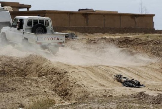 Xe của lực lượng người Shiitte kéo lê thi thể một chiến binh IS trên đường phố. Ảnh: Reuters