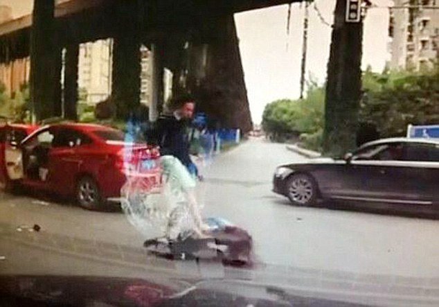 Người đàn ông lôi cô gái ra khỏi xe và đánh đấm túi bụi khiến cô ngã lăn ra đường - Ảnh chụp từ clip