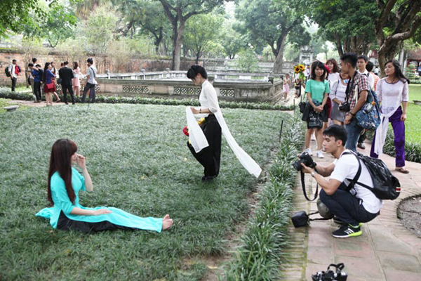 Nữ sinh viên mặc áo dài giẫm lên thảm cỏ để lưu lại cho mình những bức hình đẹp.