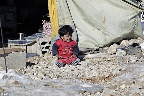 
Một em bé Syria đang ngồi khóc tại tại một trại tị nạn ở Arsal ở Lebanon. Chính cuộc nội chiến vô nghĩa kéo dài đã đánh cắp tuổi thơ của các em, đẩy các em vào hoàn cảnh không nhà, không gia đình, không được đi học. (Ảnh: AP)
