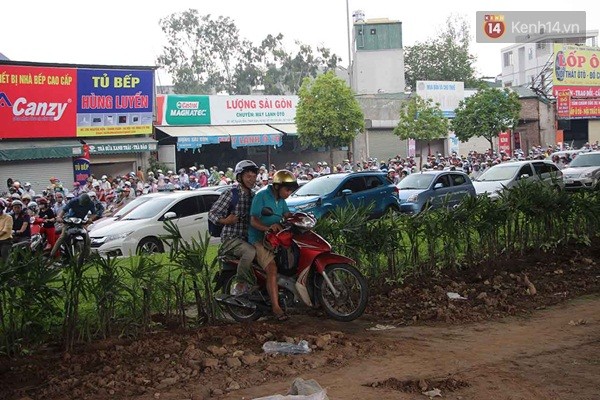 
Nhiều xe máy trèo qua dải phân cách và cả bãi đất ngăn làn đường để thoát khỏi tình trạng tắc nghẽn. Ảnh: Định Nguyễn.
