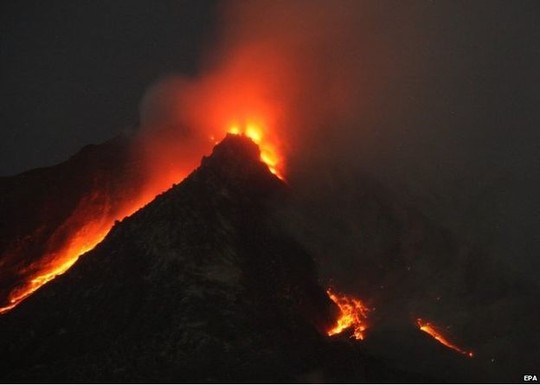 Mount Sinabung spews hot gas and lava as seen from Tiga Serangkai village in Karo, North Sumatra, Indonesia, 14 June 2015
