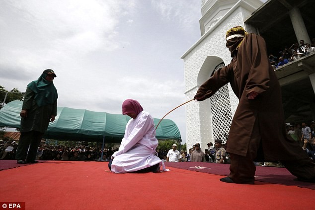 Một phụ nữ quỳ chịu roi ở tỉnh Banda Aceh, Indonesia. Đây là địa phương duy nhất ở Indonesia duy trì hình phạt bằng roi đối với những người vi phạm luật Hồi giáo.