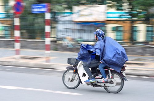 Một số phụ huynh đưa con đi học sáng sớm mặc áo mưa để giữ ấm cho con nhỏ.