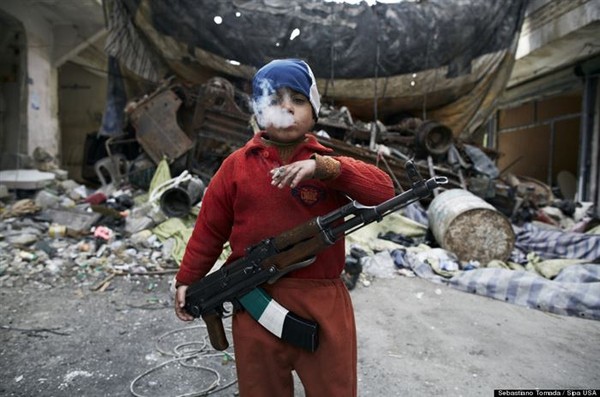 Đôi mắt của một tuổi thơ bị đánh cắp- Trong ảnh là một chiến binh phe nổi loạn tại Syria. Em mới chỉ 8 tuổi nhưng đã biết cầm súng AK47 và hút thuốc lá. Sâu thẳm trong mắt em có lẽ là sự gào thét của một đứa trẻ bị tước đi những tháng ngày ngây ngô nhất.
