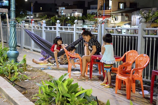 Bất chấp nguy hiểm, nhiều gia đình vẫn cho các em nhỏ ngồi chơi bên bờ kênh.