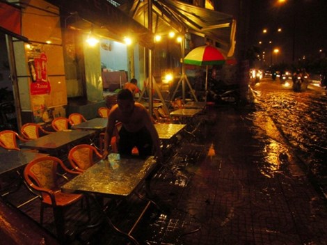 Nhiều chủ quán trên đường Phạm Văn Đồng (phường 3, quận Gò Vấp) phải sơ tán đồ đạc vì nước ngập chảy xiết. Ảnh: Phước Tĩnh