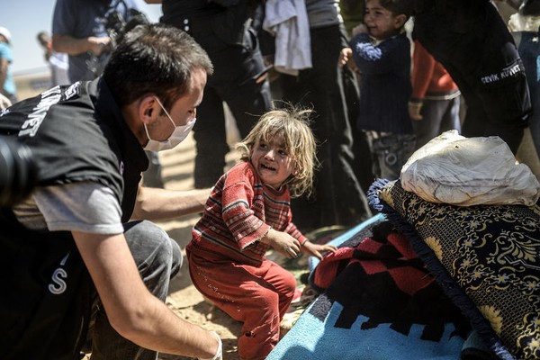 
Một bé gái Syria khóc thét sợ hãi khi một cảnh sát Thổ Nhĩ Kỳ kiểm tra hành lý của gia đình em khi họ vượt qua biên giới giữa Syria và Thổ Nhĩ Kỳ. Mỗi năm, có hàng trăm người Syria di cư đến các nước xung quanh để chạy trốn khỏi chiến tranh dai dẳng tại đất nước này. (Ảnh: AFP)
