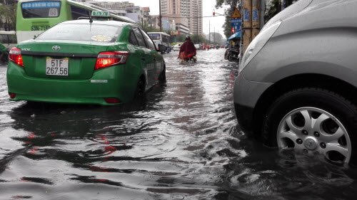 Xe máy, ô tô di chuyển khó khăn ở giao lộ Phú Giáo - Hồng Bàng vì nước ngập sâu.