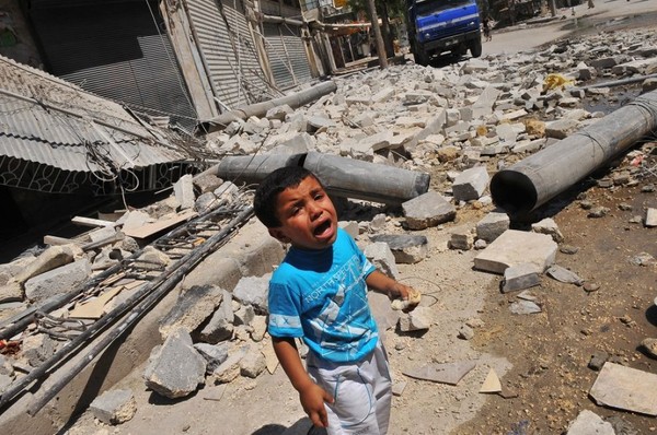 
Một cậu bé Syria đang khóc vì đau đớn và lo sợ trước đống đổ nát hoang tàn do chiến tranh gây ra.
