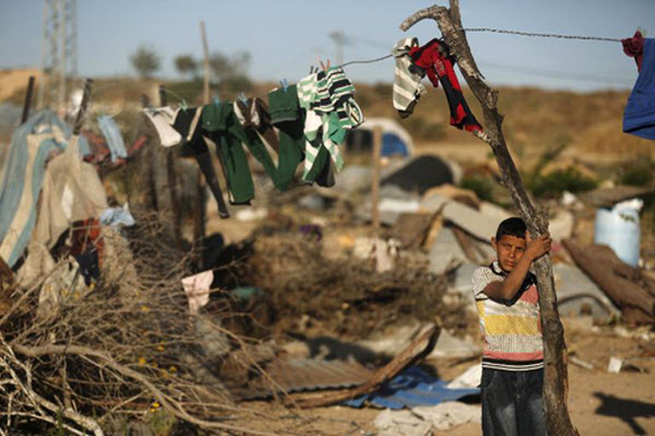 Cậu bé Palestine đứng giữa đống đổ nát của ngôi nhà tại khu phố Johar al-Deek gần biên giới với Israel, ở trung tâm thành phố Gaza.