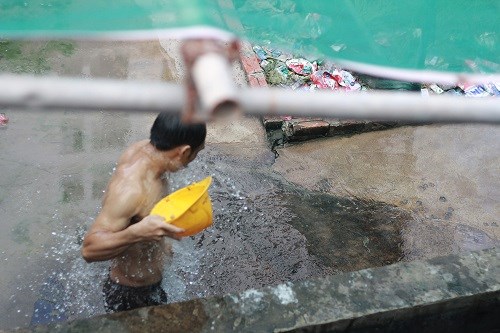 Công nhân tắm ngay tại công trường - ảnh Trí Lâm