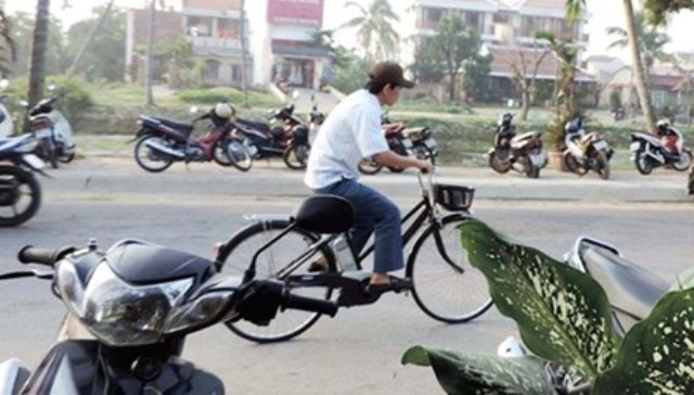 Ông Nguyễn Sự đi làm bằng xe đạp. (Ảnh: Tiền Phong)