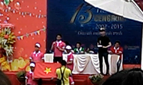 Ông Trần Minh Long - Tổng giám đốc phía Nam hệ thống siêu thị Dự án bất động sản STDA (người đứng, bên trái) lĩnh xướng 500 nhân viên hát bài Cen ca chế lời bài Quốc ca gây phản cảm. Ảnh: Vietnamnet.