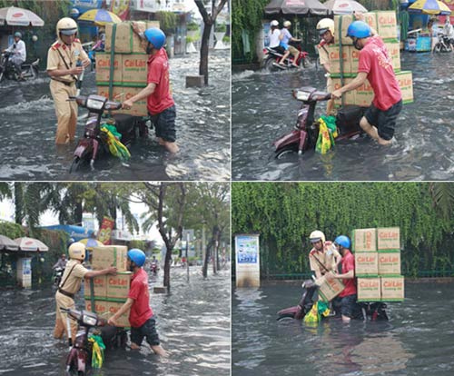 
Thấy xe một người chở hàng bị chết máy giữa biển nước, anh CSGT đã đến giúp mang từng thùng hàng vào nơi khô ráo.
