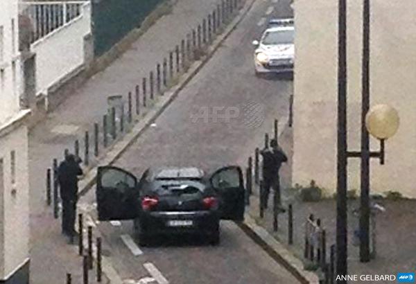 Hai tên khủng bố nã đạn vào xe cảnh sát trước khi thoát khỏi hiện trường.