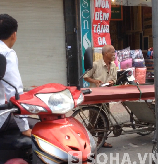 
Ông Bình đang dừng xe hàng lại để hỏi một số người lái xe ôm về địa chỉ của khách hàng.
