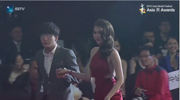 Hình ảnh Bê Trần cầm tay đưa Ngọc Trinh lên sân khấu nhận giải thưởng.