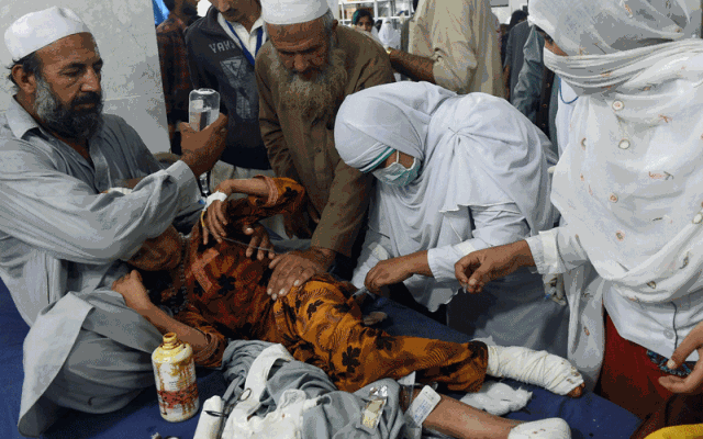 
Các bác sĩ chăm sóc một bé gái bị thương ở Peshawar. Ảnh: AFP
