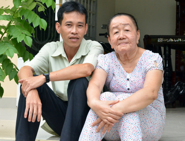 Vợ chồng chị Phượng ngồi trước ngôi nhà ở huyện Mỏ Cày Bắc, Bến Tre (ảnh chụp ngày 13-4-2013, sau chuyến đi Nga) - Ảnh: Quỳnh Trung