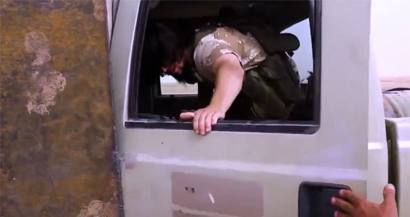 
Một phiến quân IS đang trèo vào cabin xe. (Ảnh: Breibart)
