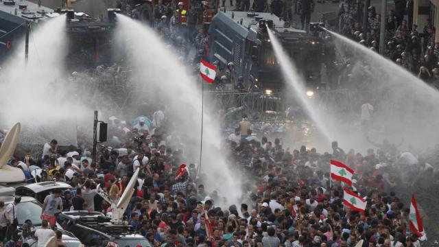 
Cảnh sát phải dùng vòi rồng để giải tán đám đông biểu tình ở Lebanon. Ảnh: Reuters
