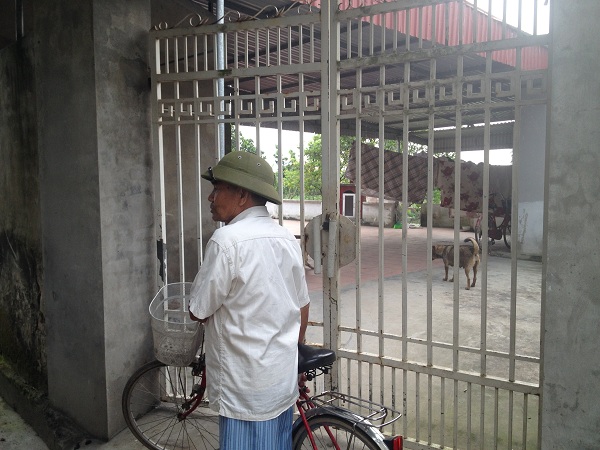 Ông Nguyễn Văn Mùi trước cổng ngôi nhà khóa trái của vợ chồng anh Quảng, chị Đôi