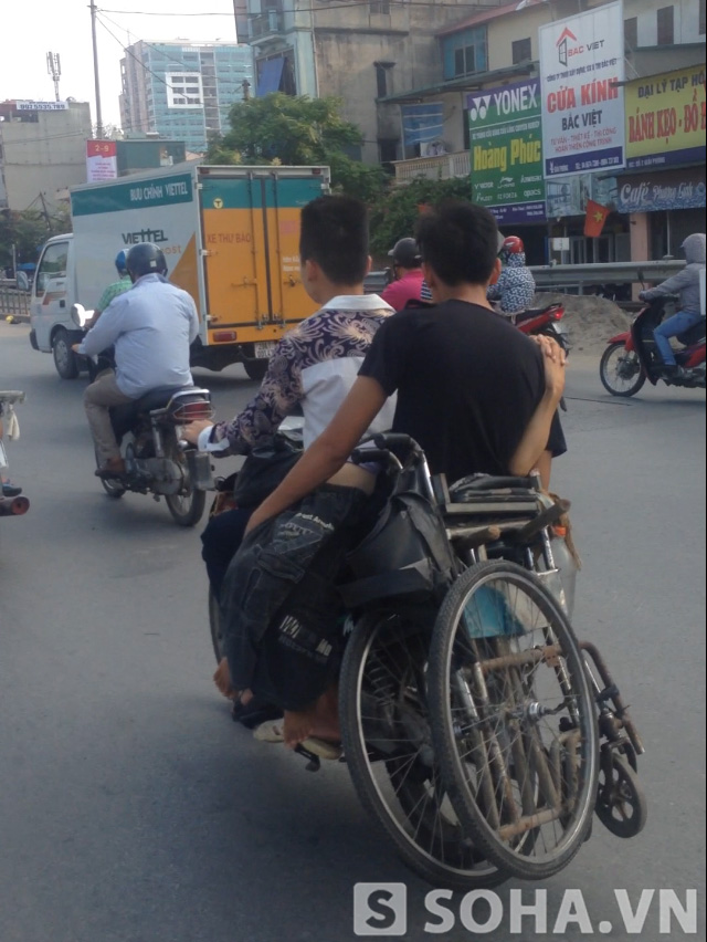 Trên quãng đường rất dài, hai thanh niên chở người khuyết tật đi tốc độ khá nhanh.