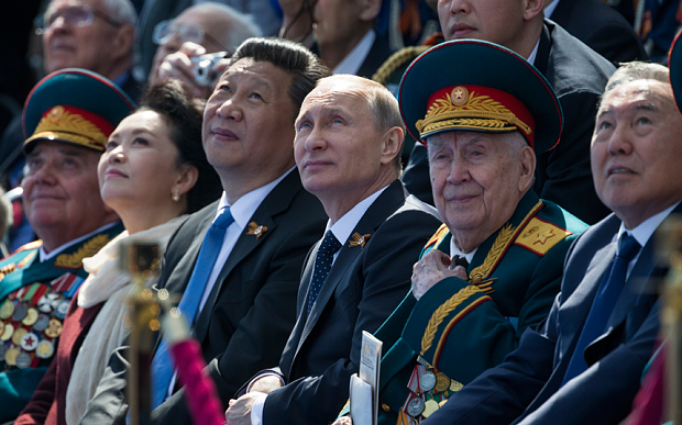 Lãnh đạo Nga-Trung ngồi cạnh nhau trong buổi lễ diễu binh kỉ niệm Ngày Chiến thắng tại Quảng trường Đỏ. Ảnh: Reuters