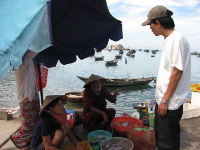 Ông Nguyễn Sự trò chuyện với bà con ngư dân, vận động bà con “nói không với túi nilông”. (Ảnh: Hoàng Duy/ Tuổi Trẻ)