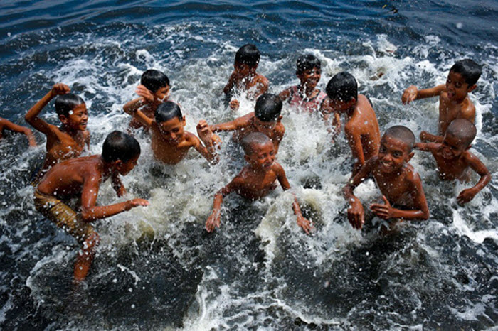 Các em nhỏ tắm sông để tránh cái nóng khắc nghiệt ở thủ đô Dhaka của Bangladesh.