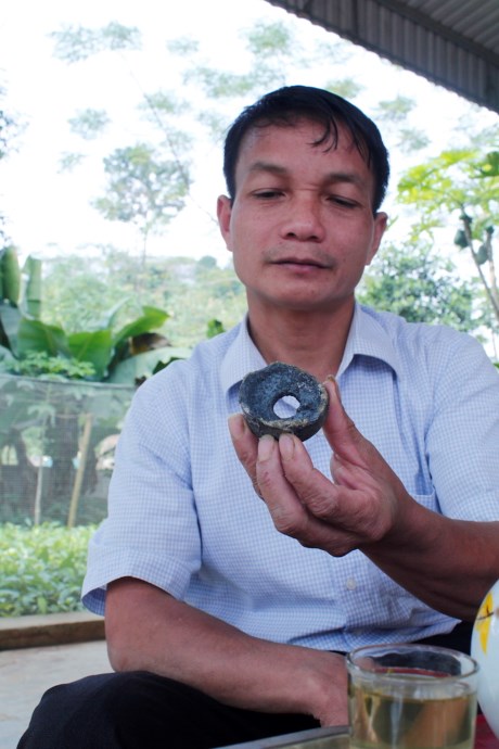 Ông Tạ Duy Trinh - Xã đội phó xã Tân Đồng (huyện Trấn Yên, Yên Bái) cầm mảnh vỡ rơi xuống nhà dân. Ảnh: Lao động