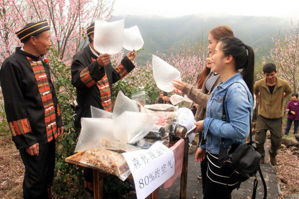 
Khách du lịch đến Quảng Đông đang hỏi mua những túi khí do người dân địa phương bán trên đỉnh núi.
