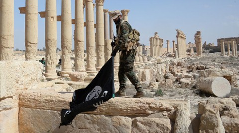 Lính Syria tháo cờ IS sau khi giành lại kiểm soát Palmyra.