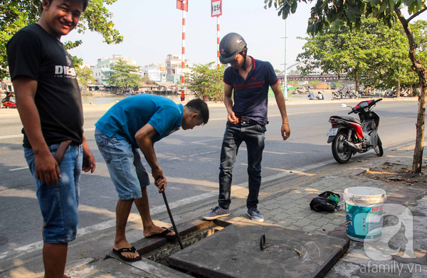 Cứ mỗi chiều về, nhiều người dân ở TP.HCM lại tập trung câu cá ngay trên các nắp cống hộp trên đoạn đường Nguyễn Tất Thành, phường 13, quận 4. Để bắt đầu câu, họ dùng thanh sắt lậy nắp hố ga ra.