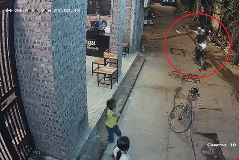 Hai nam thanh niên đi xe máy, ném chiếc phích chứa sơn và mắm tôm vào cửa quán ăn.