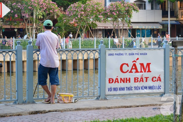 Những biển báo với dòng chữ “Cấm đánh bắt cá với mọi hình thức trên kênh Nhiêu Lộc” được đặt dọc khắp con kênh song dường như chẳng mấy người để ý đến chúng. Ảnh: Afamily/TTVN