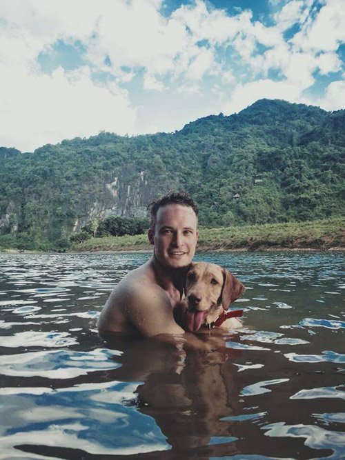Nhân viên thuộc đội hậu cần và chú chó cưng thoải mái vui đùa dưới hồ Yên Phú.
