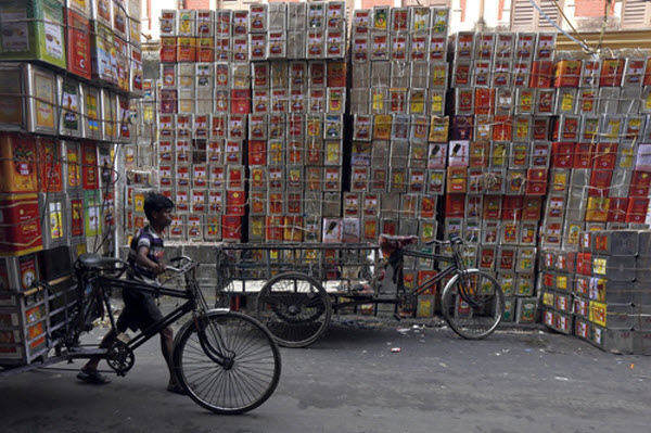 Người đàn ông dắt chiếc xe đạp chở những thùng đựng dầu ăn tại một nhà xưởng ở Kolkata, Ấn Độ.