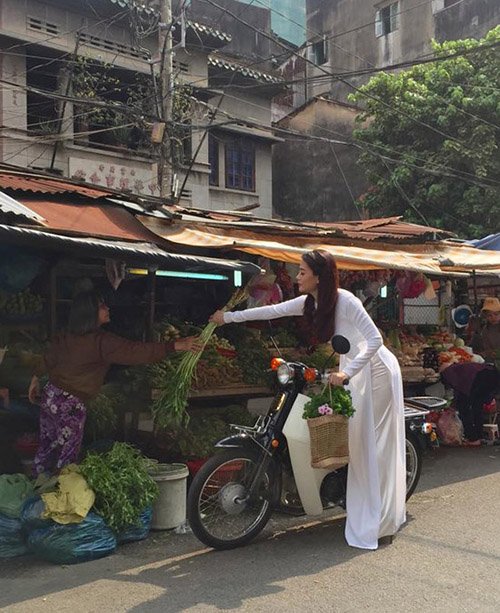 
Trương Ngọc Ánh tranh thủ ghé quầy hàng thực phẩm mua rau nhân dịp thực hiện bộ ảnh thời trang.
