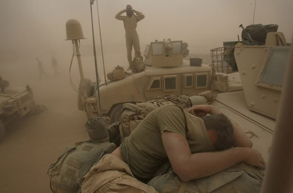 Một lính thủy quân lục chiến tranh thủ chợp mắt ngay trên xe thiết giáp bất chấp bụi cát phủ kín người.