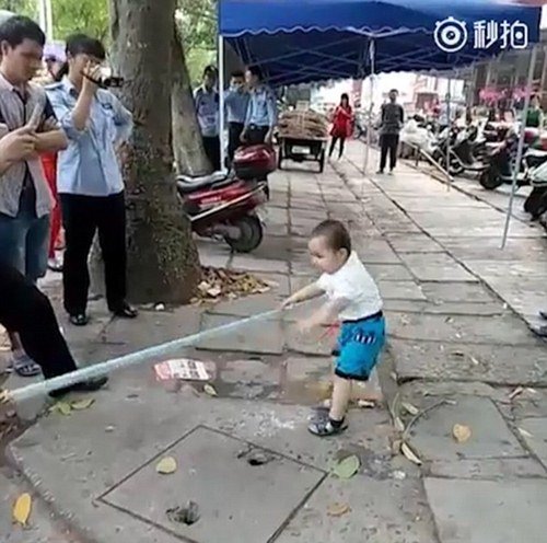 Cậu bé cầm cả cây gậy và la hét lớn để dọa nạt người khác