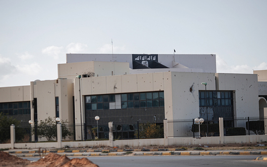 Cờ đen của IS xuất hiện trên mái nhà Trung tâm Hội nghị Ougadougou conference ở Sirte, Libya. Ảnh: Reuters