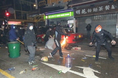 Người biểu tình tấn công cảnh sát. Ảnh: SCMP