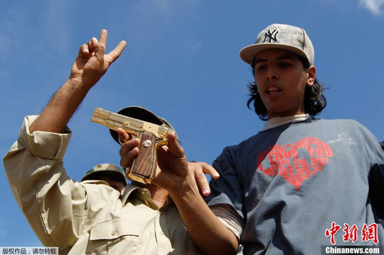 Omran Shabaan và khẩu súng vàng của ông Gaddafi. Ảnh: Sina