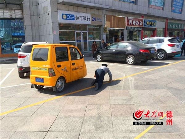 
Nữ tài xế cố đi dù bảo vệ đã quỳ gối. (Nguồn: CCTVNews)
