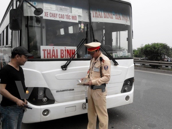 
Cảnh sát giao thông kiểm tra xe khách vi phạm. (Ảnh: Việt Hùng/Vietnam+)
